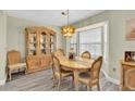Formal dining room featuring a light wood table and chairs set illuminated by a unique chandelier and a display cabinet at 4841 Wakefield Ct # 4841, New Port Richey, FL 34655
