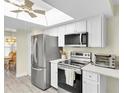 Bright kitchen features stainless steel appliances, white cabinetry, a skylight, and breakfast area at 4841 Wakefield Ct # 4841, New Port Richey, FL 34655