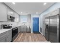 Renovated kitchen with stainless steel appliances, light wood floors, and blue door at 4939 Floramar Ter # 611, New Port Richey, FL 34652