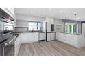 Modern kitchen featuring stainless steel appliances, white cabinetry, and a large island at 5145 Porpoise Pl, New Port Richey, FL 34652