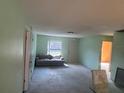 Spacious living room with carpet flooring and a light gray sofa by the window at 5391 Pillar Ave, Spring Hill, FL 34608