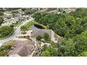 Aerial view of a suburban single-story home with mature trees and a pond in the backyard at 5747 Fieldspring Ave, New Port Richey, FL 34655