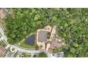 Aerial view of a single-story house surrounded by trees and a pond at 5747 Fieldspring Ave, New Port Richey, FL 34655