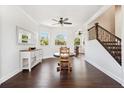 Dining area with hardwood floors, large windows, ceiling fan, and staircase in view at 7340 Brightwaters Ct, New Port Richey, FL 34652