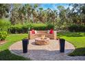 Beautiful outdoor fire pit area with built in bench and lush, landscaped yard at 7340 Brightwaters Ct, New Port Richey, FL 34652