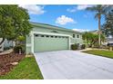 Attractive single-level home with a two-car garage and lush green landscaping at 8149 Ambersweet Pl, Land O Lakes, FL 34637