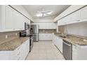 Bright kitchen featuring white cabinetry, stainless steel appliances, and granite countertops at 8248 Sugarbush Dr, Spring Hill, FL 34606