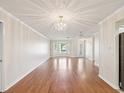 Spacious living room with hardwood flooring, decorative lighting, and a large bay window at 8248 Sugarbush Dr, Spring Hill, FL 34606