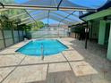 Inviting screened-in pool surrounded by a spacious tile patio, perfect for outdoor relaxation at 10277 Rosetti Ct, Spring Hill, FL 34608