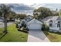 A bright single-Gathering home featuring manicured landscaping, a long brick driveway, and a two-car garage at 1084 Vista Fina Ct, Spring Hill, FL 34608