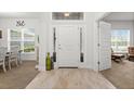 Bright foyer features wood-look tile, transom window, and views into the dining and living spaces at 11042 Heth Ct, Weeki Wachee, FL 34613