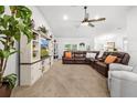 Spacious living room features a vaulted ceiling, a ceiling fan, and a large sectional sofa at 11042 Heth Ct, Weeki Wachee, FL 34613