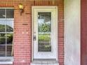 Elegant front door with decorative glass detailing set within a brick facade at 11340 Corinthian St, Spring Hill, FL 34609