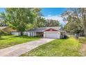Inviting single-story residence showcasing a spacious front yard, driveway, and two-car garage at 11340 Corinthian St, Spring Hill, FL 34609