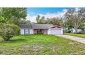 Charming single-story home with a well-manicured lawn and a two-car garage and brick features at 11340 Corinthian St, Spring Hill, FL 34609