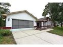 Charming single-story home with white exterior and a two-car garage and driveway at 11364 Orangewood Ct, Spring Hill, FL 34609