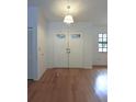 Bright foyer featuring wood floors, double front doors and a hanging light fixture at 11364 Orangewood Ct, Spring Hill, FL 34609