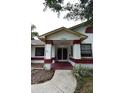 Inviting front entrance with covered porch, decorative columns, and well-maintained landscaping at 11364 Orangewood Ct, Spring Hill, FL 34609