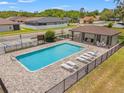 Community pool with lounge chairs, a covered picnic area, and secure fencing at 11579 Weaver Hollow Rd, New Port Richey, FL 34654