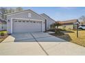 A lovely single-Gathering home with a gray exterior, landscaped yard, and attached two-car garage at 11637 Spindrift Loop, Hudson, FL 34667