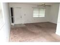 Bright living room with neutral carpet, a ceiling fan, and a screen door for inviting fresh air and natural light at 11715 Boynton Ln # 74B, New Port Richey, FL 34654