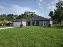 Lovely single-story home with lush green lawn, modern gray exterior, and an attached two-car garage at 12064 Cradock St, Spring Hill, FL 34608