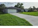 Beautifully renovated single-story home showcasing a lush lawn, and a convenient two-car garage at 12064 Cradock St, Spring Hill, FL 34608