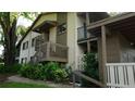 Charming building exterior featuring stairs, balcony and lush landscaping, enhancing its overall appeal at 13012 Wedgewood Way # A, Hudson, FL 34667