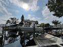 Boat in lift at wooden dock with canal and residential waterfront in background at 13626 Allyn Dr, Hudson, FL 34667