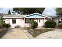 Single-story house with white trim, covered porch, mature landscaping, and concrete driveway at 13626 Allyn Dr, Hudson, FL 34667
