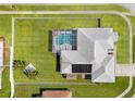 Aerial view of a property with a fenced yard, screened pool, and solar panels on the roof at 13627 Lightning Rod Ct, Hudson, FL 34669