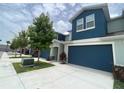 Charming townhouse with a well-manicured lawn and a blue garage door and clean driveway at 1508 Figleaf Ln, Clearwater, FL 33756