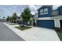 Inviting townhome featuring a blue garage door, clean driveway, and well-kept landscaping at 1508 Figleaf Ln, Clearwater, FL 33756