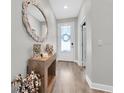 Inviting entryway with hardwood floors, mirror, console table, and natural light at 15241 Caravan Ave, Odessa, FL 33556