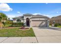 Attractive single-story home featuring a manicured lawn, decorative fountain, and a two-car garage at 1623 Crossvine Ct, New Port Richey, FL 34655