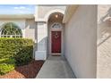 Close-up view of the front door entrance with its inviting red door and decorative wreath at 1623 Crossvine Ct, New Port Richey, FL 34655