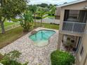 Aerial view of a private backyard oasis featuring a pool, brick patio, and manicured landscaping at 17905 Machair Ln, Land O Lakes, FL 34638