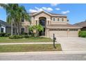 Inviting two-story home features a well-manicured lawn, mature trees, and a spacious three-car garage at 17905 Machair Ln, Land O Lakes, FL 34638