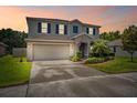 Charming two-story home features a manicured lawn, gray siding, blue shutters and an attached two car garage at 18566 Hunters Meadow Walk, Land O Lakes, FL 34638