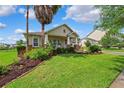 Inviting single-story home featuring a well-manicured lawn, front garden, and a cozy covered porch at 19531 Mossy Oak Ct, Brooksville, FL 34601