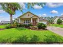 Charming single-story home featuring a well-manicured lawn, covered porch, and lush landscaping at 19531 Mossy Oak Ct, Brooksville, FL 34601