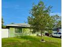 A single-story home sits on a lush green lawn under a clear blue sky at 2016 Woodward Ave, Dunedin, FL 34698