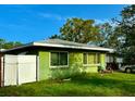 This single-story home is surrounded by greenery and has a fenced-in yard at 2016 Woodward Ave, Dunedin, FL 34698