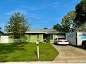 Charming single-story home features a well-maintained lawn and a private driveway at 2016 Woodward Ave, Dunedin, FL 34698