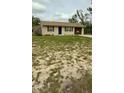 A quaint single-story home with a simple facade, large front yard and a driveway leading to covered parking at 2234 Marietta Ave, Spring Hill, FL 34608