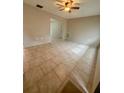 Spacious living room featuring neutral walls, tiled floors, a ceiling fan, and abundant natural light at 2234 Marietta Ave, Spring Hill, FL 34608
