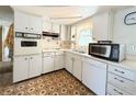 Functional kitchen featuring white cabinets and all appliances at 4142 Crestfield Ave, Holiday, FL 34691
