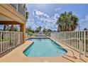 Inviting backyard pool surrounded by a white fence with a beautiful sky at 4460 Flounder Dr, Hernando Beach, FL 34607