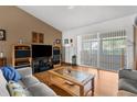 Comfortable living area featuring wood floors, large TV, and a sliding glass door at 5035 Harbinger Rd, Spring Hill, FL 34608