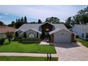 Lovely single-Gathering home featuring mature landscaping, arched windows, and a two-car garage at 5249 Wellfield Rd, New Port Richey, FL 34655
